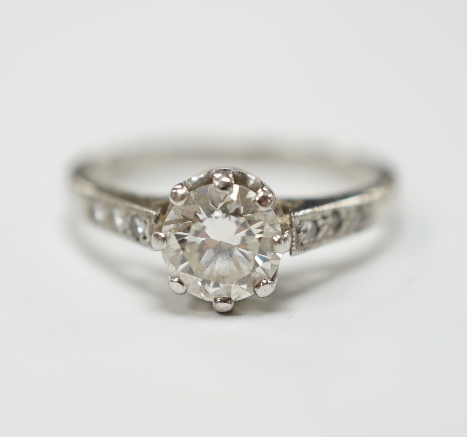 A platinum and single stone diamond set ring, with six stone diamond chip set shoulders, size P, gross weight 4.5 grams